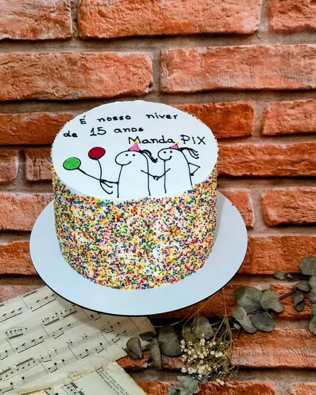 Bolo de confeites coloridos com a frase É nosso niver de 15 anos, manda Pix