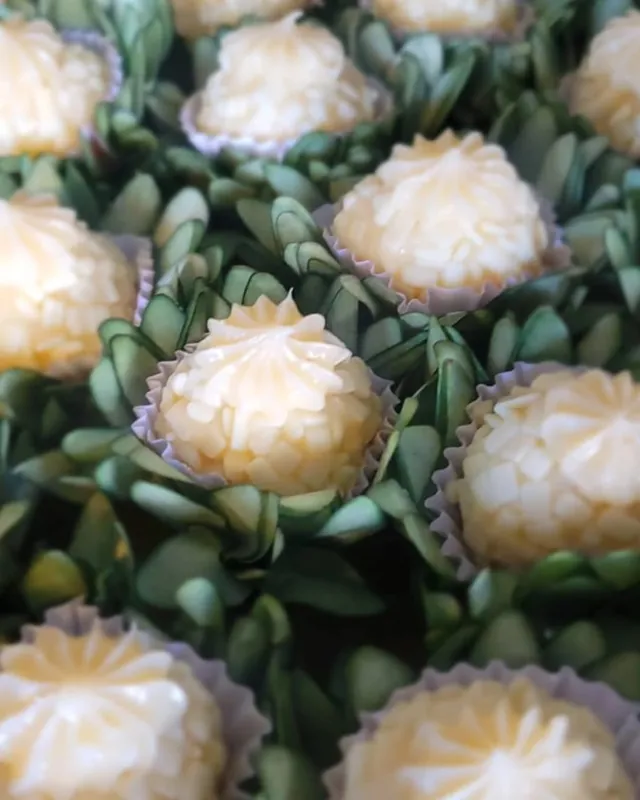 Bandeja de beijinhos em forminhas, sobre folhagem verde