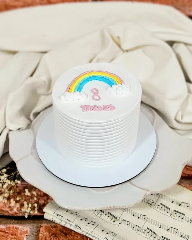 Bolo branco de mesversário com arco-íris e a frase 8 meses