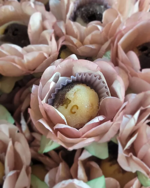 Docinhos servidos em forminhas de papel em formato de flor rosa