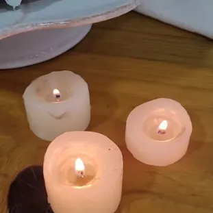 Velas acesas sobre a mesa, ao lado da boleira